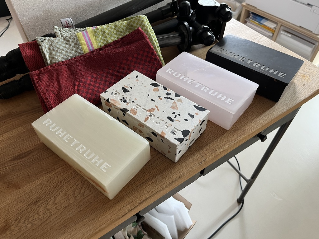 Ruhetruhe Varianten auf einem Tisch, darunter Terrazzo, Rose, Ivory und Black